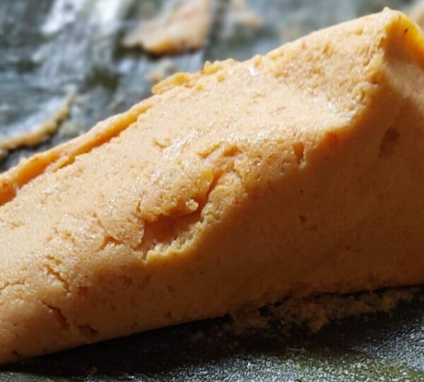 A close-up of soft, steamed Moi Moi pudding made from beans and peppers, a nutritious and comforting Lagos street food dish.