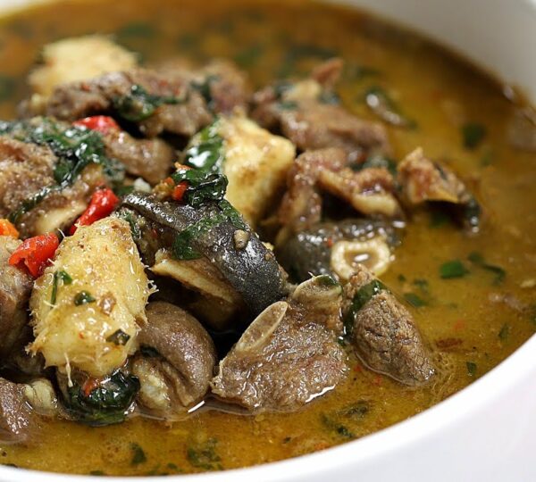  A steaming bowl of spicy Nigerian pepper soup made with assorted meat and herbs, a late-night Lagos street food favorite.