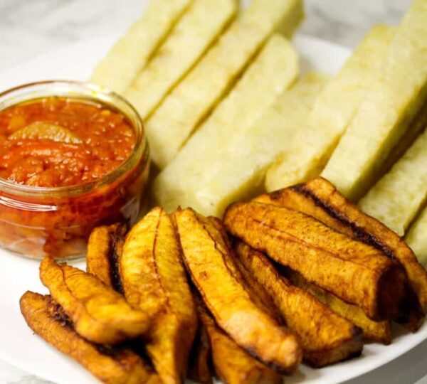 A plate of crispy fried yam served with rich pepper sauce, one of the most satisfying and spicy Lagos street foods.
