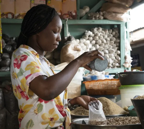 A woman measuring grains at Balogun Market, one of the busiest local markets in Lagos, Nigeria.