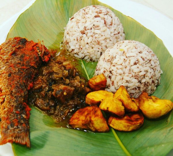A traditional serving of Ofada rice with Ayamase stew and fried plantain, a Yoruba classic enjoyed as Lagos street food.