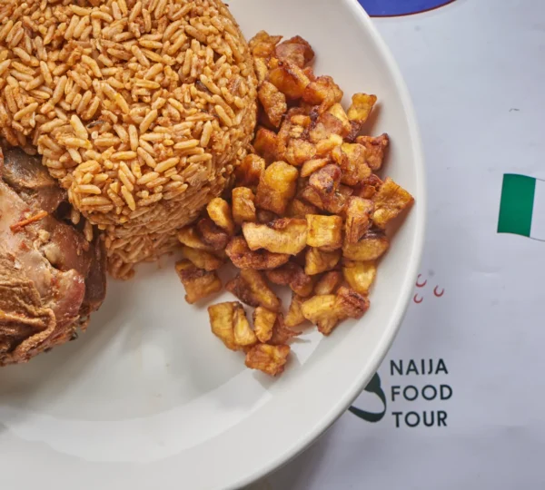 Jollof rice with fried plantain and turkey — one of the most famous foods in Nigeria enjoyed by visitors.
