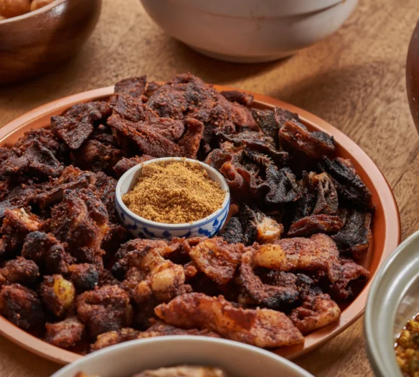 Nigerian Suya — spicy grilled beef skewers seasoned with pepper and served with onions and tomatoes, one of the street foods featured alongside Fufu and Egusi Soup on Naija Food Tour.