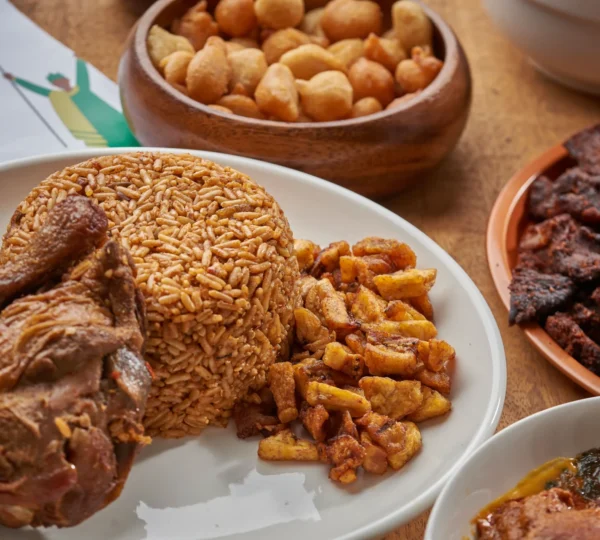 Gourmet Jollof rice with plantain and goat meat, a popular dish highlighted in Naija gourmet food experiences.