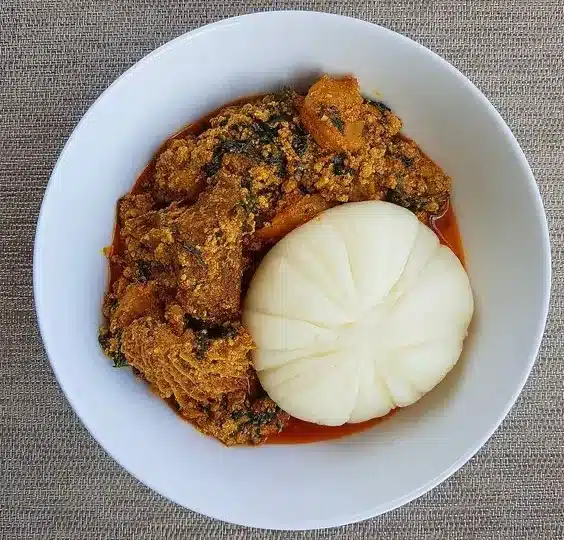 Egusi soup and pounded yam served in a white bowl — a classic healthy Nigerian food combination.