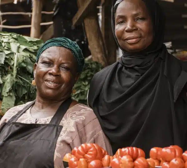 Local market women in Lagos showcasing fresh produce and Nigerian spices during a food tour in Lagos Nigeria.