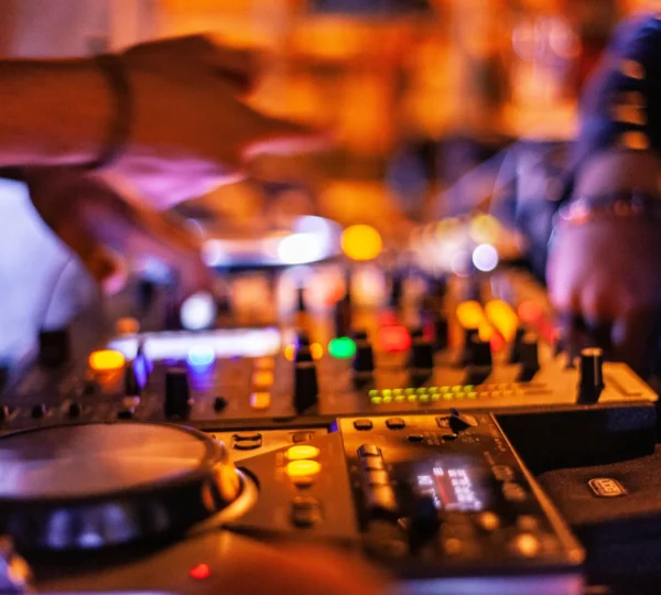 DJ mixing music at a Lagos nightclub with colorful lights — nightlife adventures are among the most exciting fun things to do in Lagos.